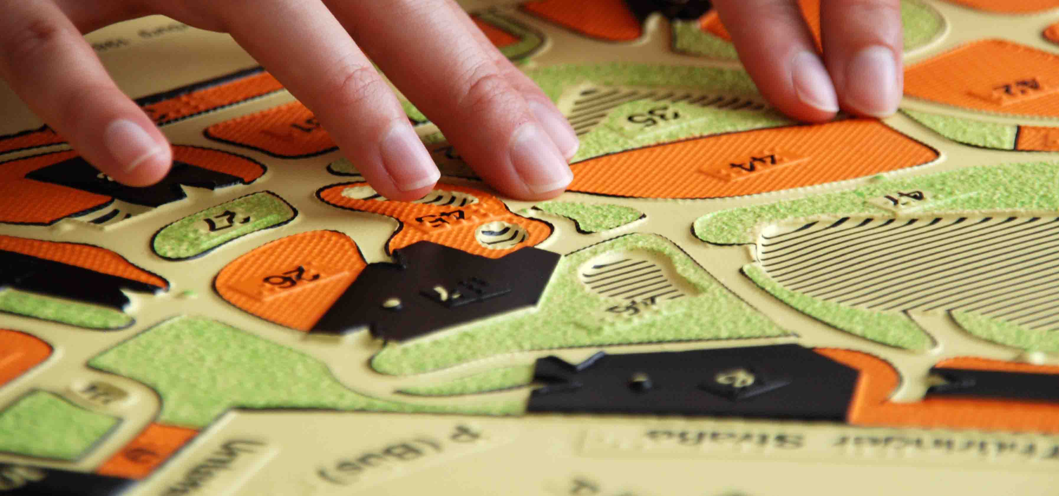 Finger fahren über einen taktilen Stadtplan